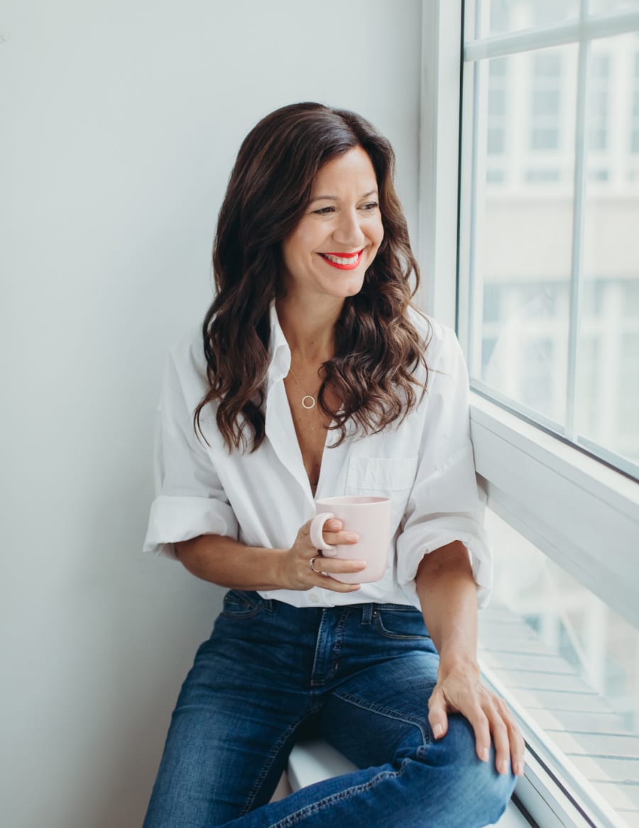Life coach and psychotherapist Katarina Stoltz in a white blazer looking up smiling. She thanks you for signing up to her Time To Thrive newsletter.