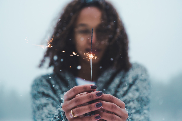 Woman with sparkler representing a life coach reflecting on the learnings of the past year