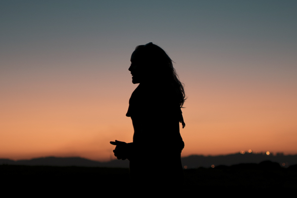 woman being mindful in the sunset