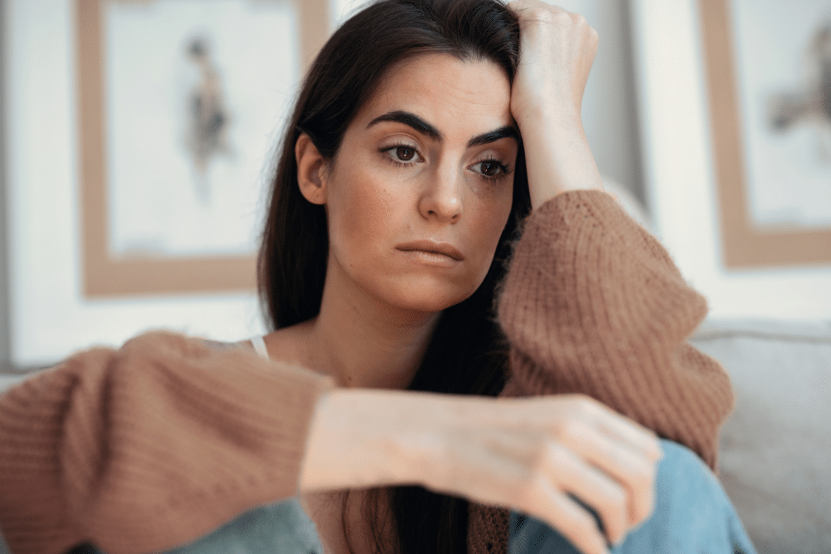 Woman in brown top contemplating burnout from a toxic workplace