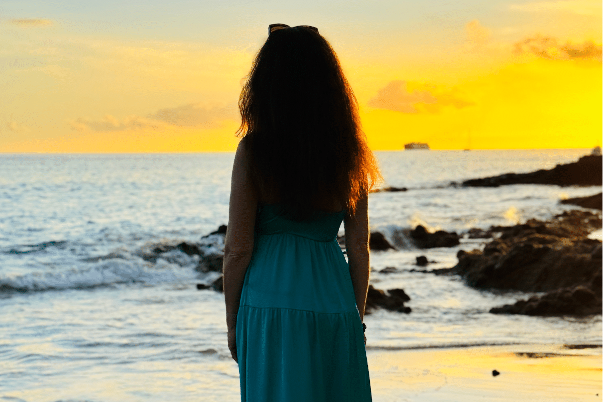 Life coach and therapist Katarina Stoltz looking out over the ocean at sunset in contemplation