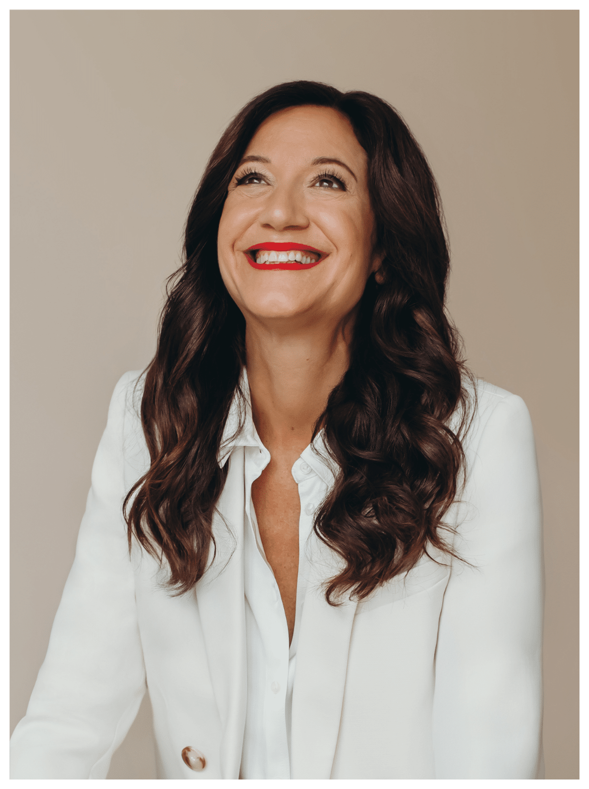 Life coach and psychotherapist Katarina Stoltz in a white blazer looking up smiling. She thanks you for signing up to her Time To Thrive newsletter.