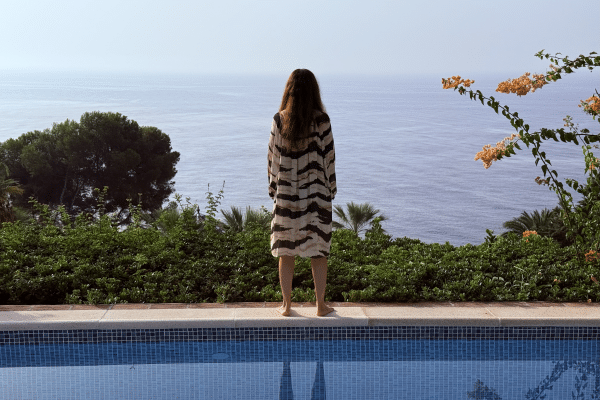 Life coach Katarina Stoltz stood by pool overlooking view in Spain as she reflects and listens to her inner voice.