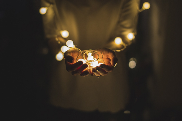 hands holding fairy lights representing starting the year with less resentment