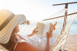 rest without guilt - woman in hammock reading on the beach