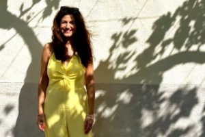 Life coach Katarina Stoltz in Mallorca wearing a yellow jumpsuit smiling at the camera