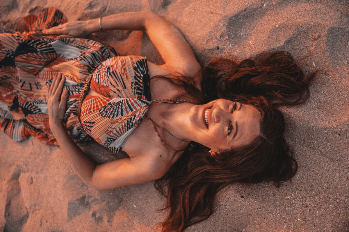 Life coach and therapist Katarina Stoltz lying on the sand having time alone  in Thailand while not feeling guilty.