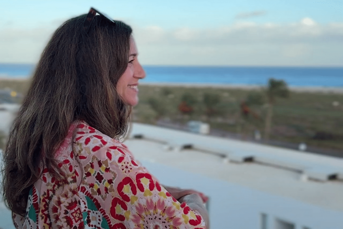 Life coach and therapist Katarina Stoltz looking out over balcony smiling while reflecting