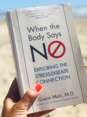 Katarina Stoltz Coaching and Therapy holding a copy of When the Body Says No by Gabor Mator
