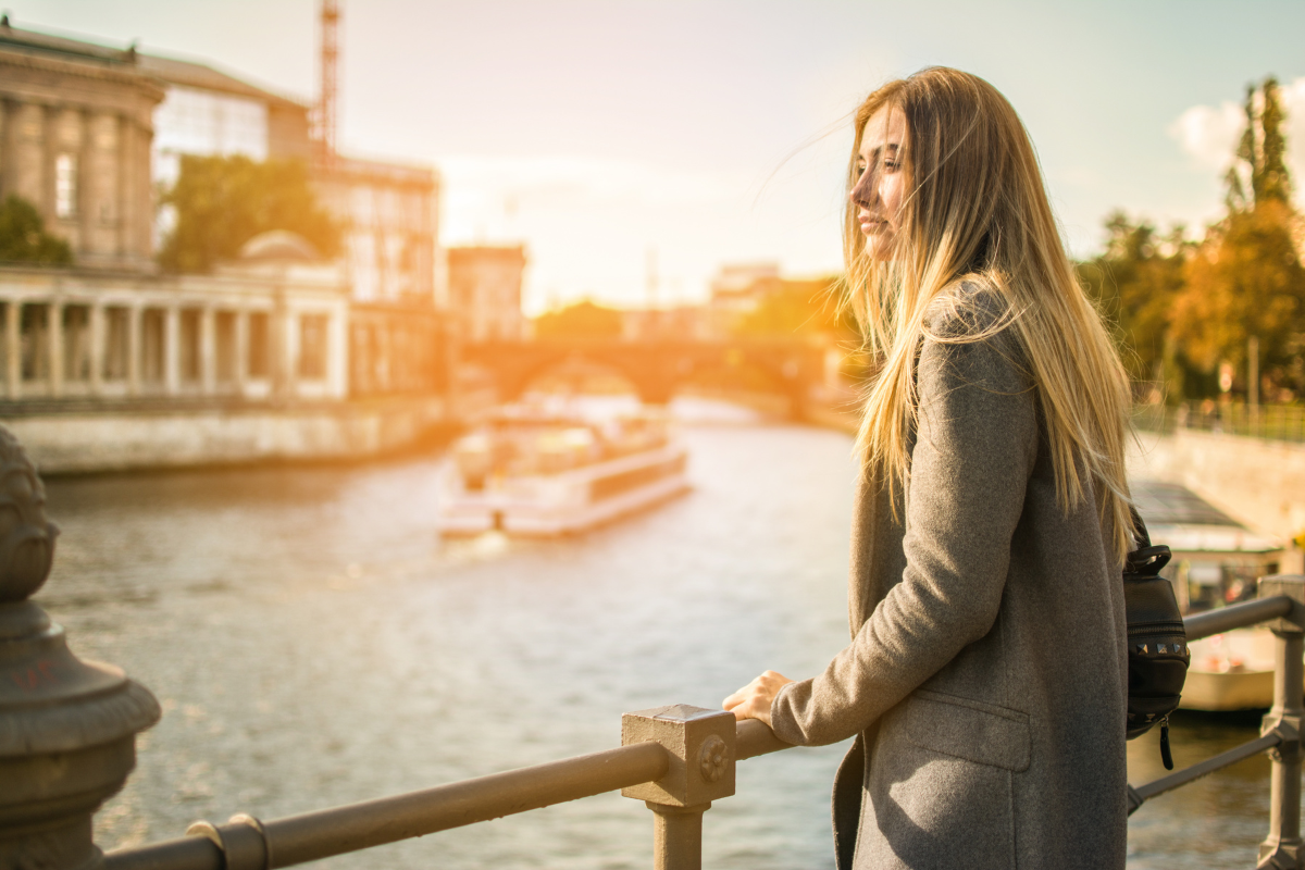 Young female expat overlooking the Spree in Berlin at sunset